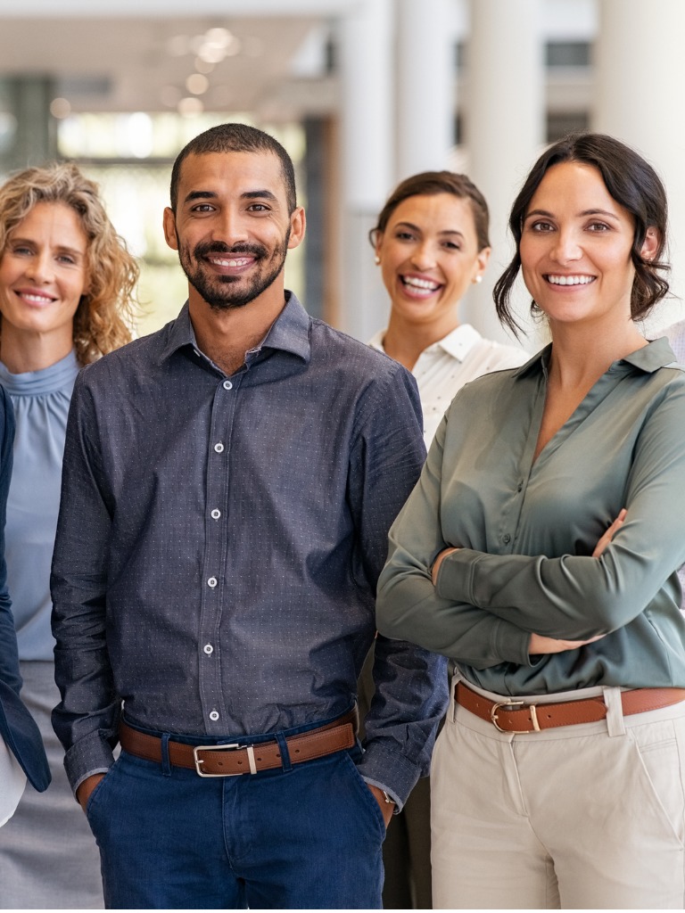 Diverse business team smiling in office, diverse professionals in business attire looking at camera